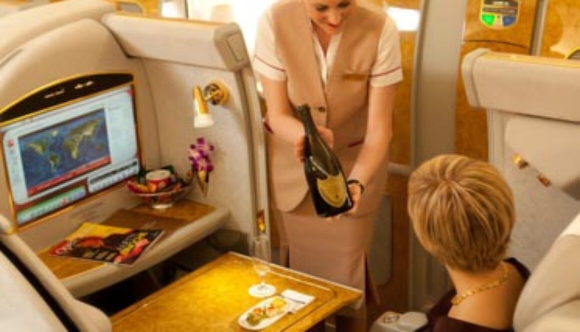 Flight attendant serving champagne on first class