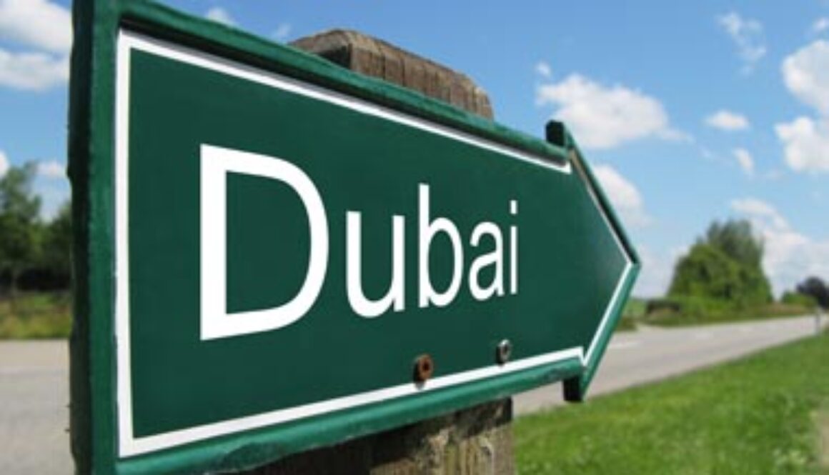 Green road sign pointing towards Dubai